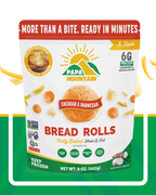 Papa Mountain Cheddar & Parmesan cheese bread rolls packaging — gluten-free certified, non-GMO, grain-free, soy-free; clean-label, no seed oils (made with extra-virgin olive oil and virgin coconut oil); fully baked heat & eat, ready in 7 minutes; 6g protein per serving; frozen cheese bread rolls / gluten-free dinner rolls for weeknight family meals, air fryer, and game-day appetizers; Georgia-grown, family-owned — buy online.Papa Mountain Cheddar & Parmesan cheese bread rolls served warm — crisp-golden outs