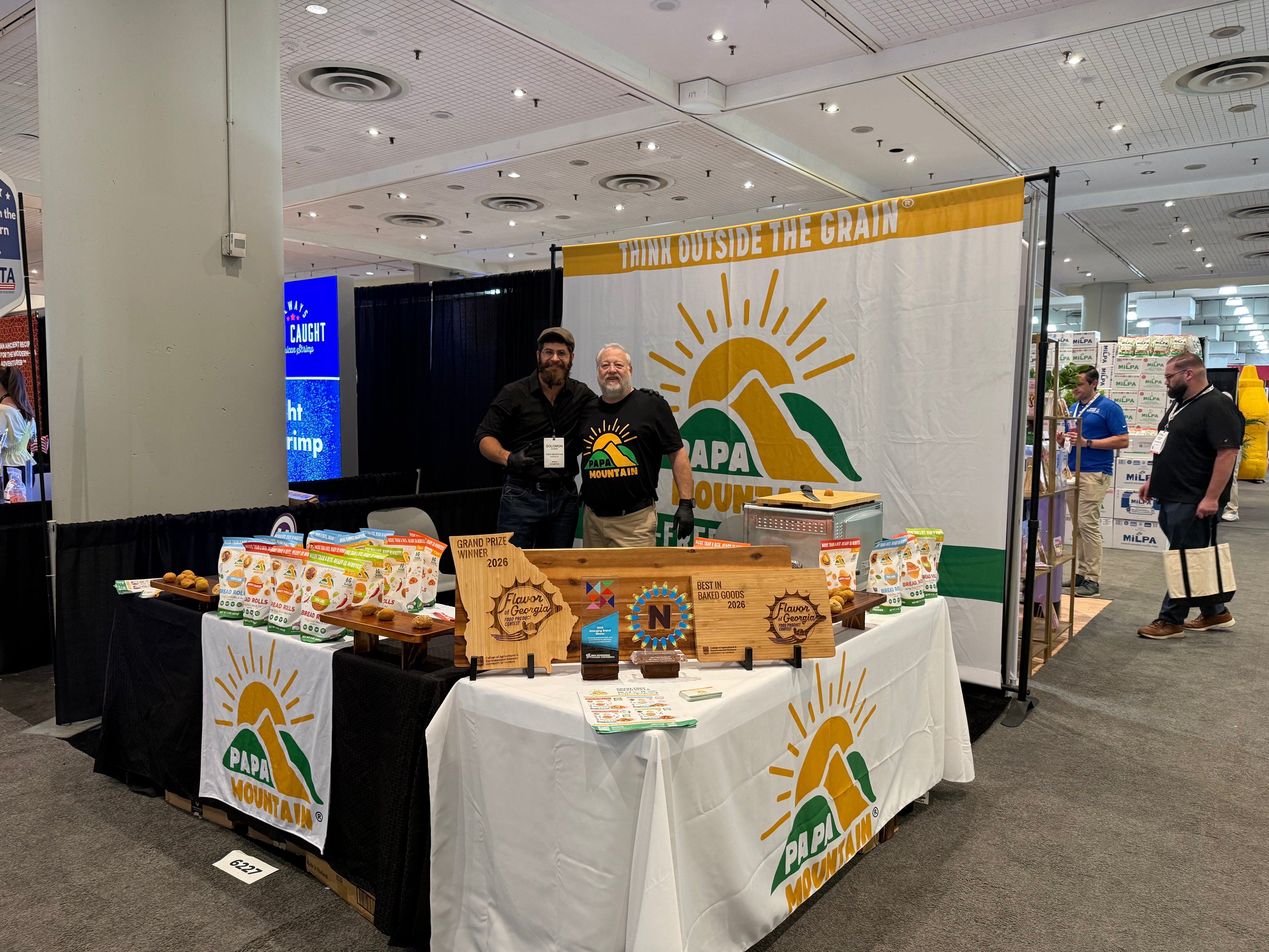 Solomon Cohen, founder of Papa Mountain, at the brand's booth at the Fancy Food Show in NYC 2026, displaying the Grand Prize Winner, Best in Baked Goods, and NEXTY Award trophies alongside Papa Mountain bread roll products