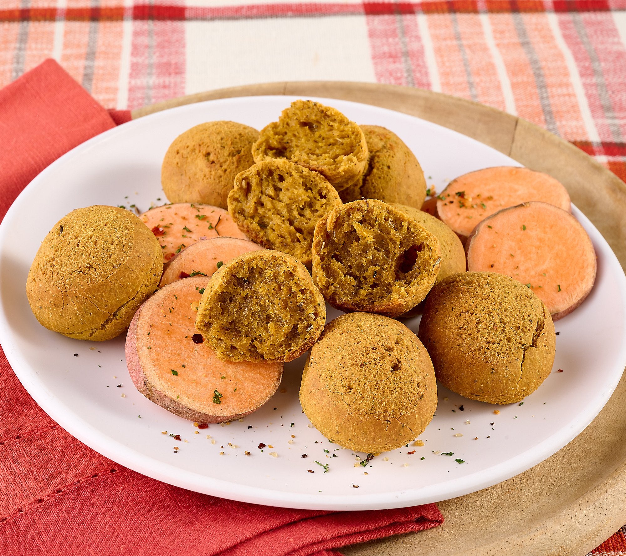 Plate of round and sliced sweet potatoes on a white plate with a red and white checkered tablecloth.papa mountain sweet potato and herb bread rolls made of cassava frozen heat and eat